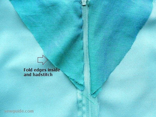 hand stitch the facing to the zipper from the back