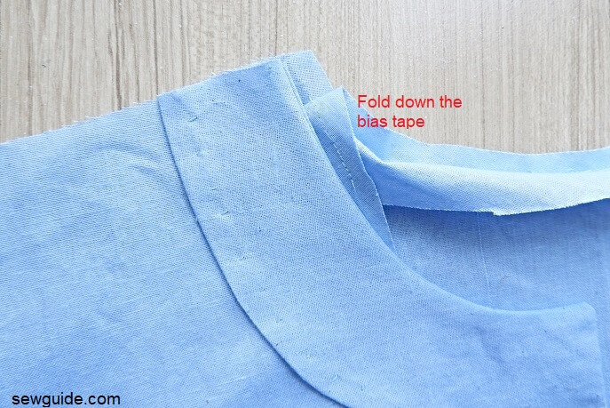 Fold down the bias tape at the back. Join the shoulder seams