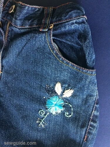 embellish jeans with small hand embroidered flower motifs