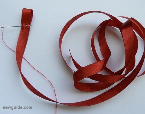 stitch a loop with the ribbon at one end